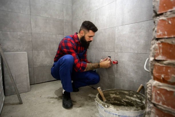 Construction worker or plumber on a construction site of a new bathroom. About 30 years old, Caucasian male.